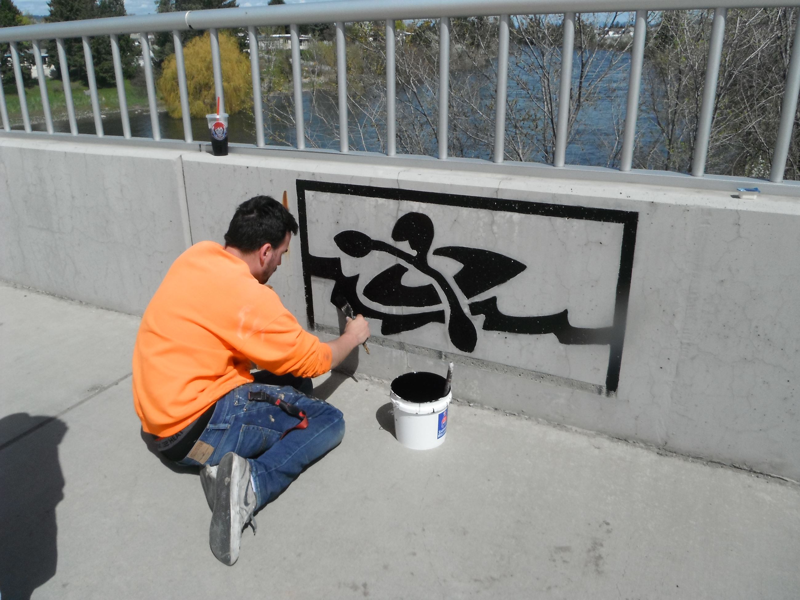 Painting of a kayak graphic on side of bridge deck railing at Sullivan Road bridge.