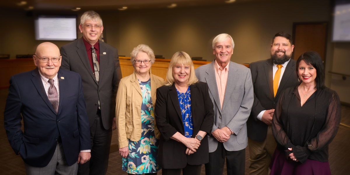 City council members posing in the council chamber.