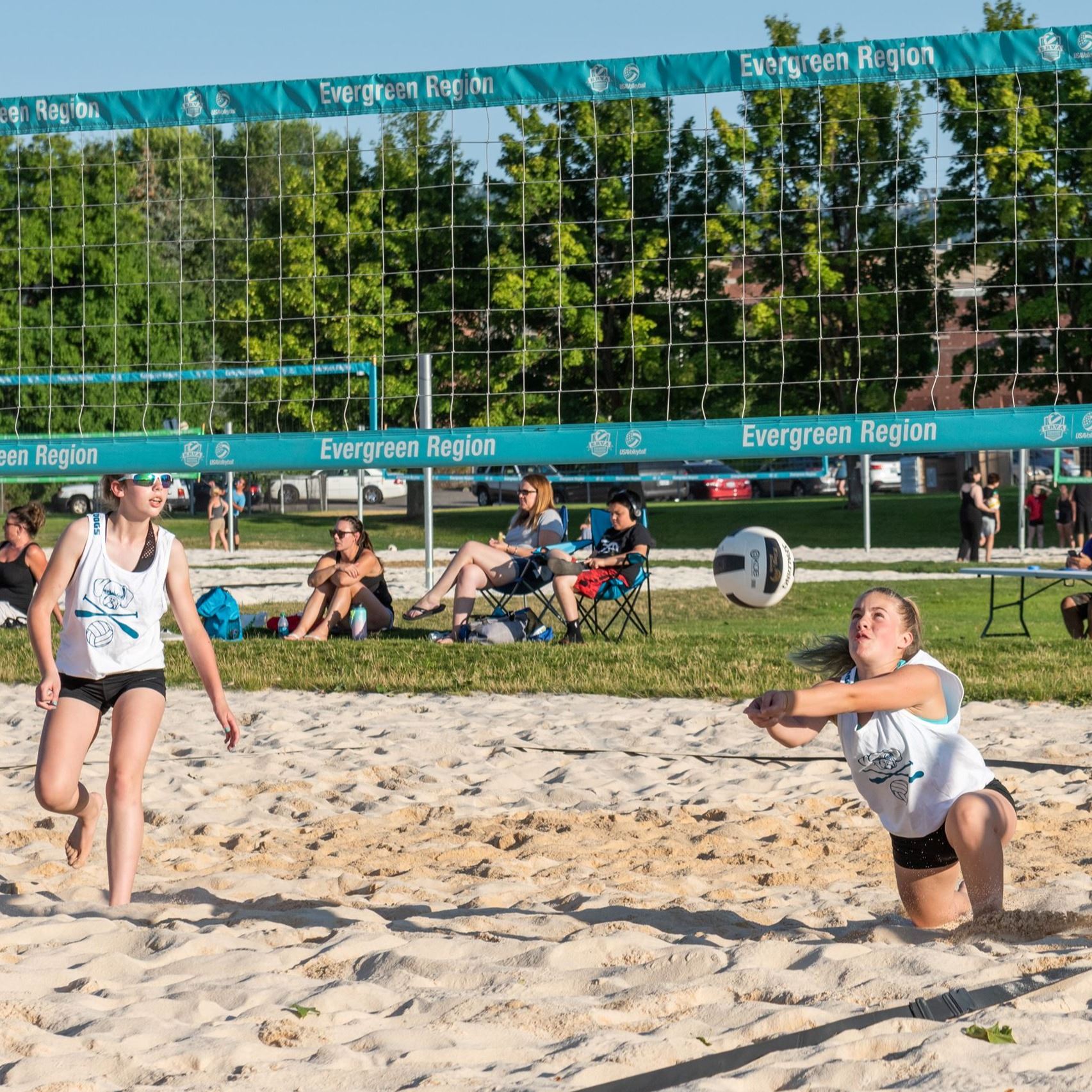 Woman diving for volleyball on sand court