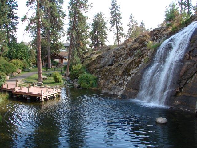 The Mirabeau Point waterfall next to a dock and park shade structure.