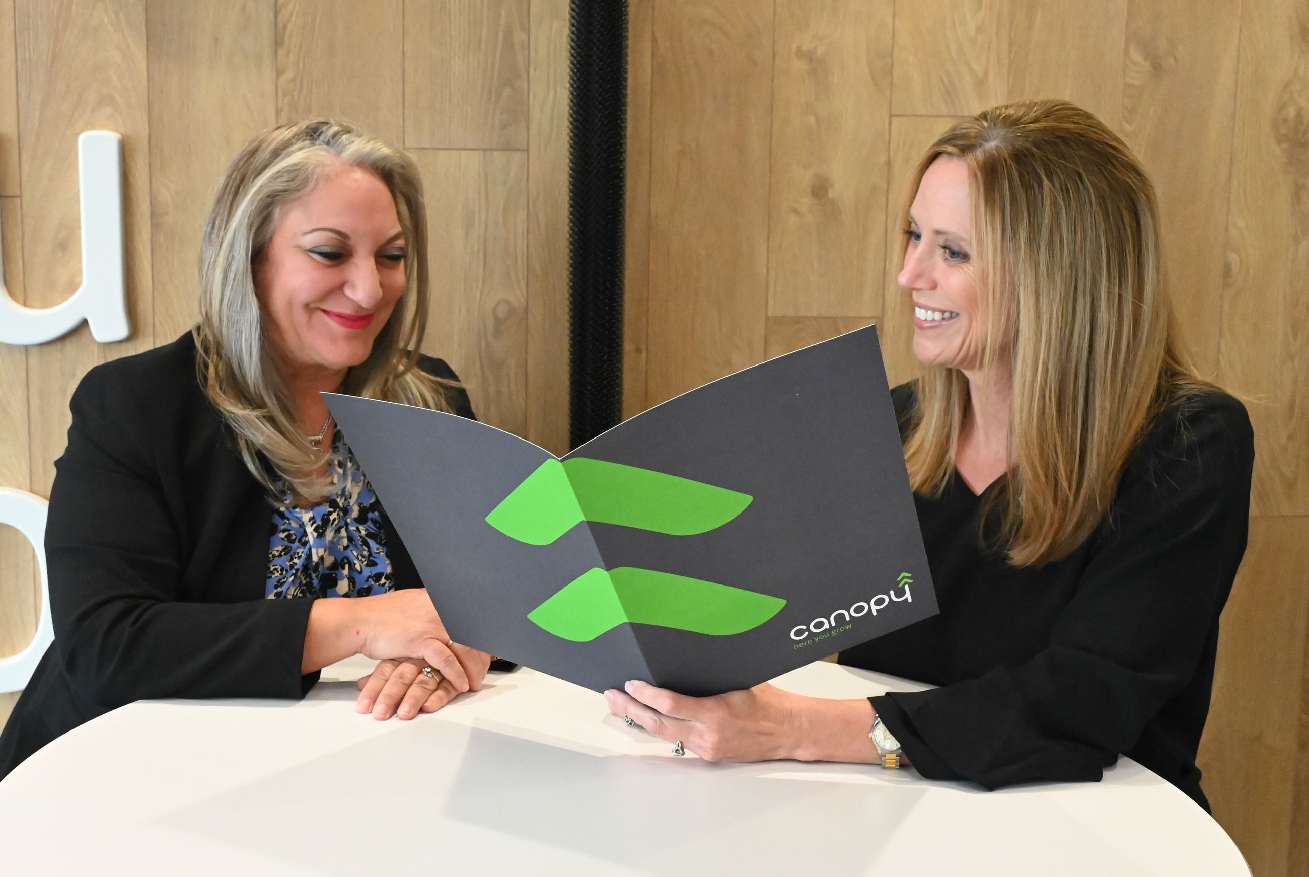 Canopy Credit Union's Charlotte Nemec shows informational materials to city employee Susan Nielse